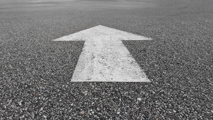 asphalt texture in the road with white paint arrow means keep forward.