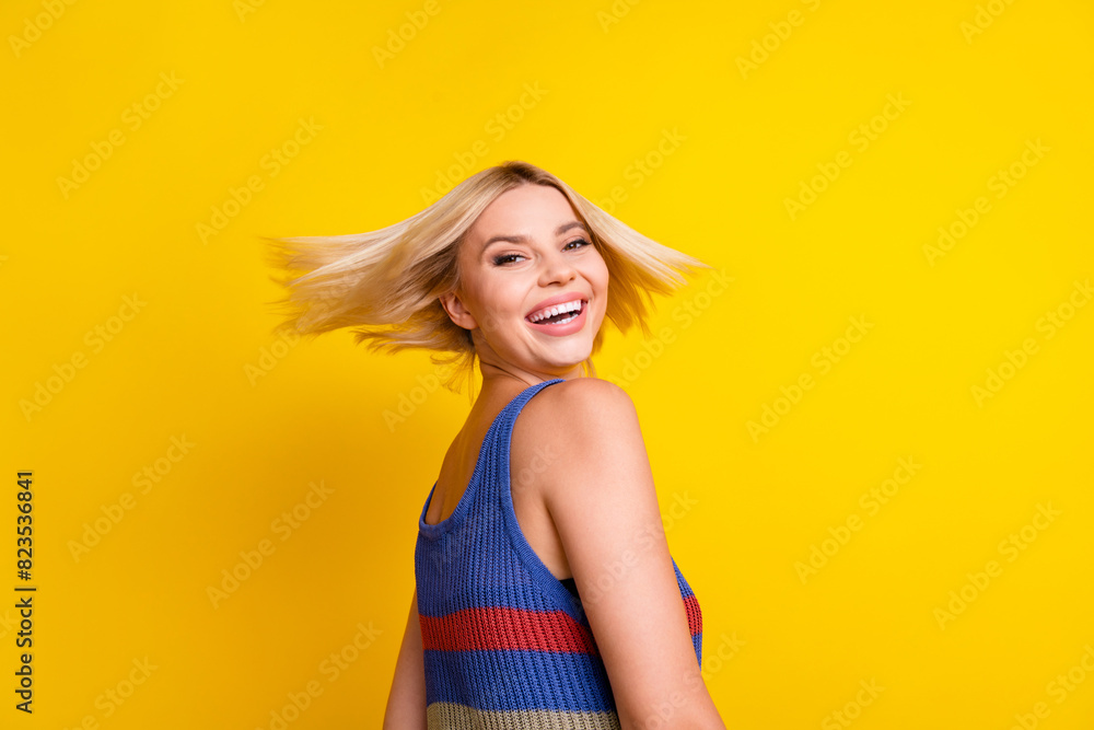 Poster Photo of young sweet model positive smiling beautiful woman in singlet moving her head blonde hair isolated on yellow color background