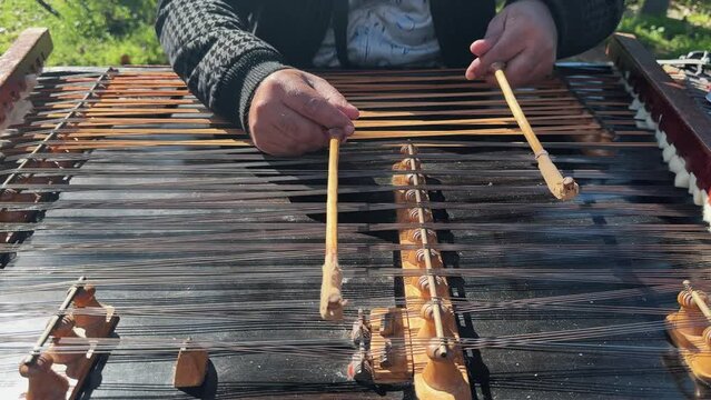 Street performer playing Iranian Santoor musical instrument, slow motion