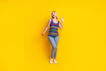 Photo portrait of young charming blonde girlfriend in jeans and singlet dancing at dancehall...