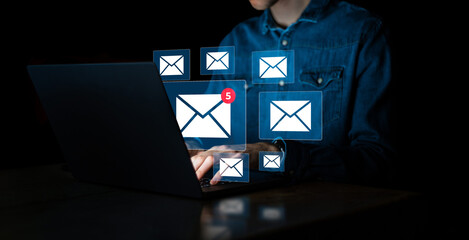 Businessman using laptop with email notification alert on virtual screen. Receiving e-mail for...