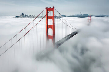 The Golden Gate Bridge partially shrouded in fog with its iconic red towers visible