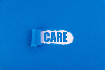 The text CARE appearing behind torn blue paper.