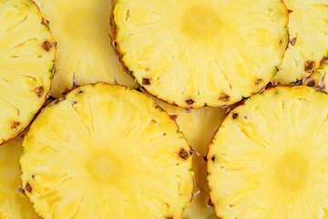 Yellow background of sliced pineapple. Top view