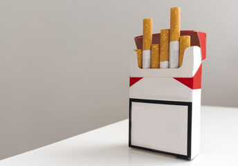 Open pack of cigarettes and a cigarette on a white background.