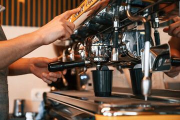 Pours a drink by using special machine. Man is serving delicious street food