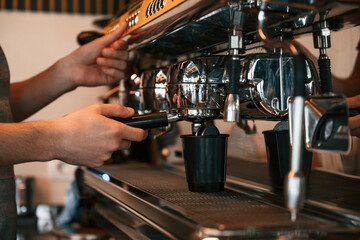 Pours a drink by using special machine. Man is serving delicious street food