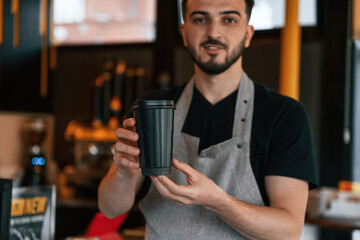 Drink is in hand. Man is serving delicious street food