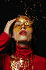 Woman wearing red latex covered in honey.
