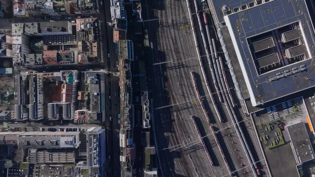 Aerial view of Geneva's railway system, highlighting the dense buildings and transportation networks while train arrives to the city