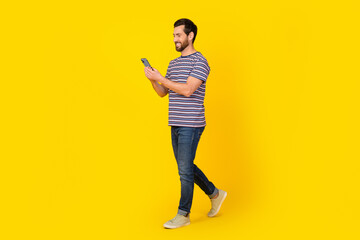 Full length body photo of young adult bearded man strolling with smartphone appove taxi order...