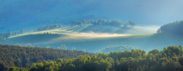 Panoramic view of mountain hills, morning mist, spring greenery, natural background	