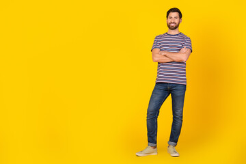 Full body length photo of model man wearing striped t shirt and denim jeans standing near empty blank space isolated on yellow color background © deagreez