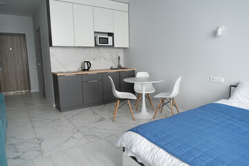 Modern interior of tiny studio appartment. Modern bedroom and kitchen in tiny home.