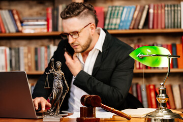 Concept of legal work, litigation. Justice and law concept. A lawyer works with a laptop in the court office.