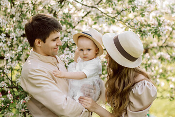 Beautiful mother and daughter in hat with father on picnic