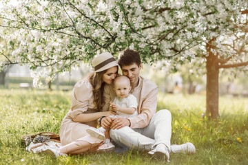Beautiful mother and daughter in hat with father on picnic