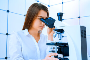 young woman in a scientific laboratory working with a microscope