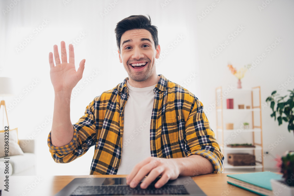 Sticker Photo of funky positive man wear checkered shirt waving arm hi communicating modern device indoors house apartment room