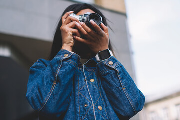 Professional female photographer making photo on vintage camera while spending time outdoors.Young...