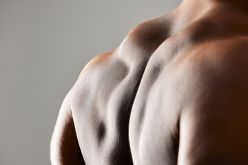 Back, closeup and bodybuilder in studio with body health, strong for fitness and exercise in gym....