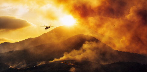 Rescue helicopter flying over a forest fire. Firefighting, ecological and emergency response...