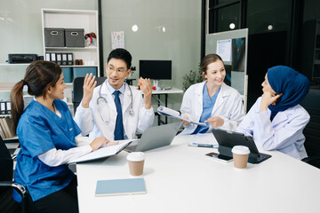 Fototapeta premium Medical, meeting and laptop for team in discussion, brainstorming and planning. Doctor, nurse on desk show diversity in collaboration, teamwork or workshop in hospital .