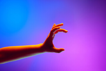 Kids hands gesturing against gradient blue purple background in neon light. Hand in position to...