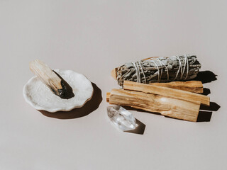 White sage and Palo Santo on a light beige background. A set of incense for fumigation