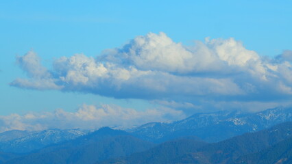 White Clouds Opposite Direction Glide Between Mountain Peaks. Iconic View Of Winter Wonderland...