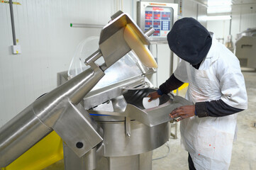 A worker cleans a machine in a food production factory