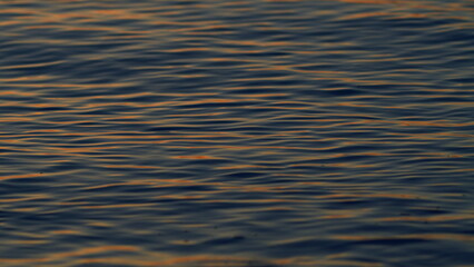 Golden Shimmering Sea Waves In Sun. View Of Calm Waves. Peaceful Summer Sunset Background. Slow motion.