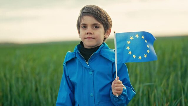 Little cute boy with European union flag in field. Happy child, kid smiling, EU