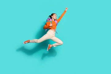 Full length photo of nice woman wear orange crop top hold rucksack copybooks fly to empty space...