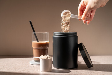 Protein shake and chocolate protein powder in a scoop, food supplement