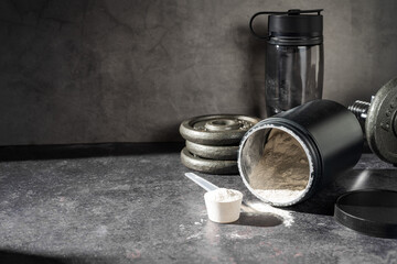 Amino acid food supplement, creatine powder in a measuring scoop and plastic jar, copy space