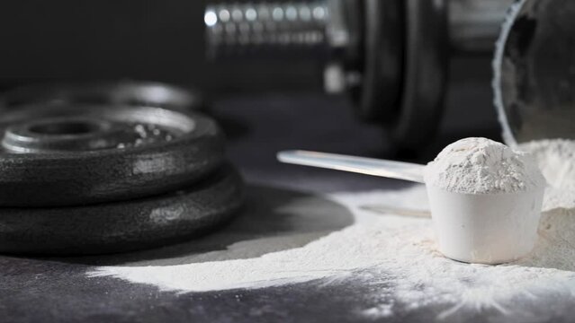 Amino acid food supplement, creatine powder in a measuring scoop and plastic jar