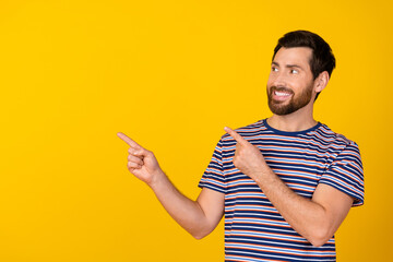 Photo of good mood man with stylish beard dressed striped t-shirt look directing at logo empty...