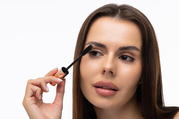 Fototapeta premium Mascara Applying. Long Lashes closeup. Mascara Brush on white background