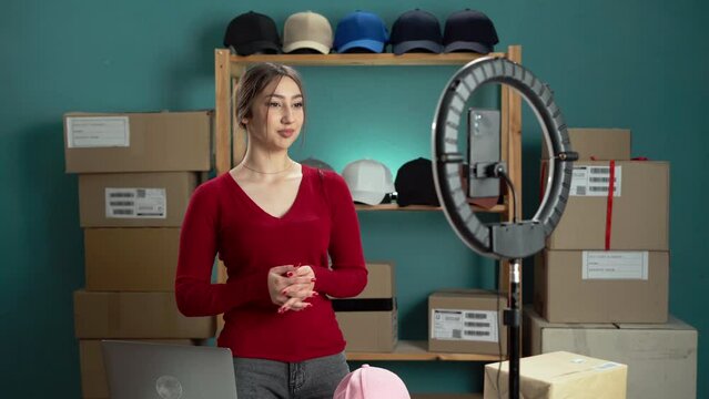 Confident woman is recording a DIY hat storage organization vlog in her home studio