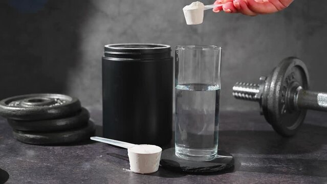 Amino acid food supplement, creatine powder in a measuring scoop and plastic jar