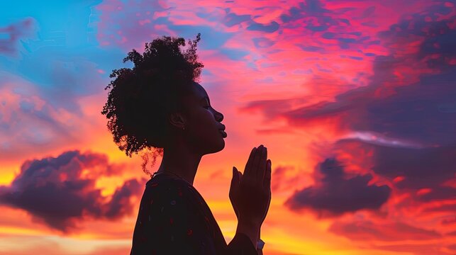 silhouette of black woman praying against vibrant sunset sky spiritual concept photography