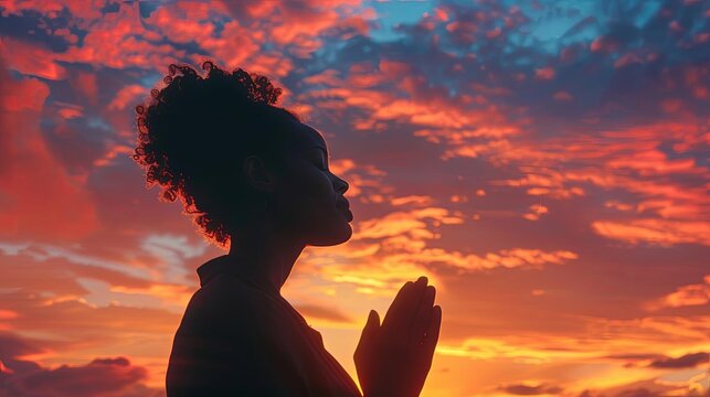 silhouette of black woman praying against vibrant sunset sky spiritual concept photography - Powered by Adobe