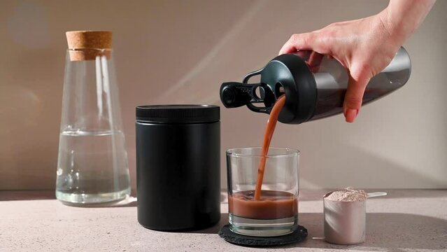 Protein shake and chocolate protein powder in a scoop, food supplement