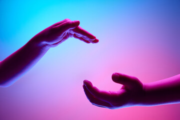 Kids hands gesturing against gradient blue purple background in neon light. Two children...