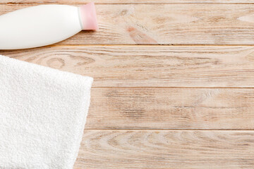 Cosmetic shampoo bottle mockup with towels on a colored table. Bathroom background, toilet...