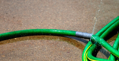 Green Hose Leaking Spraying Water