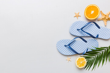 Top view composition of flip flops placed with beach accessories top view on table background....