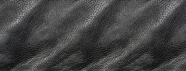 A detailed view of black leather texture with visible grain, highlighting the rich, rugged, and luxurious feel of the material.