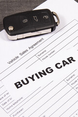 Car key, inscription buying car and form of vehicle sales agreement. Sales or purchases new or used...